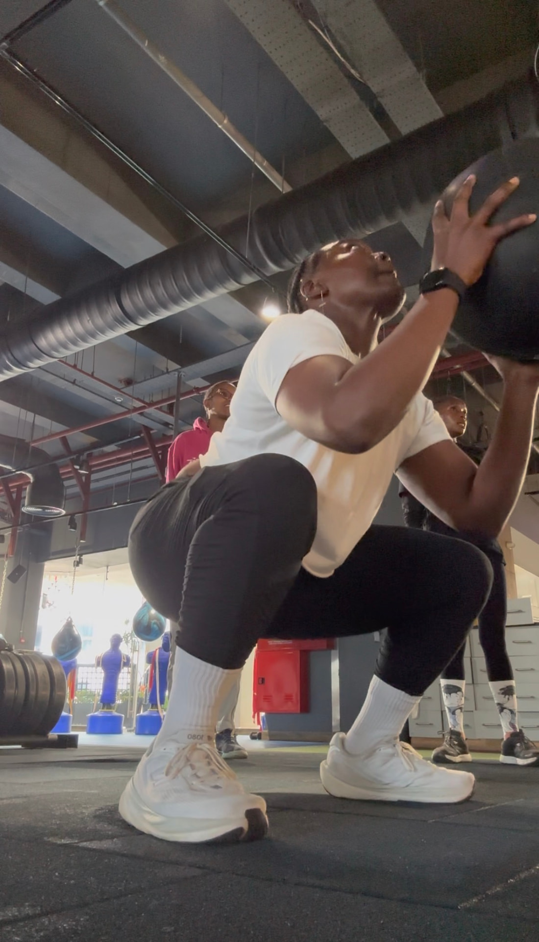 Khadijat doing a weighted squat during HYROX training in Kenya